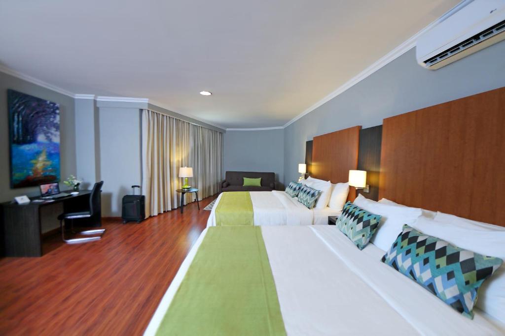 戴维阿兰胡埃斯套房酒店 的大型酒店客房设有两张床和一张书桌