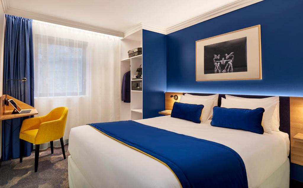 巴黎B&B HOTEL Paris 17 Batignolles的酒店客房设有一张大床和一张书桌。