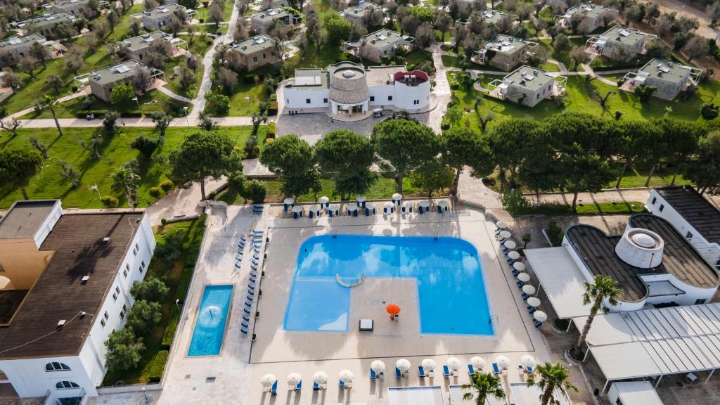 米内尔维诺迪莱切Dolmen Sport Resort的享有带游泳池的房屋的空中景致