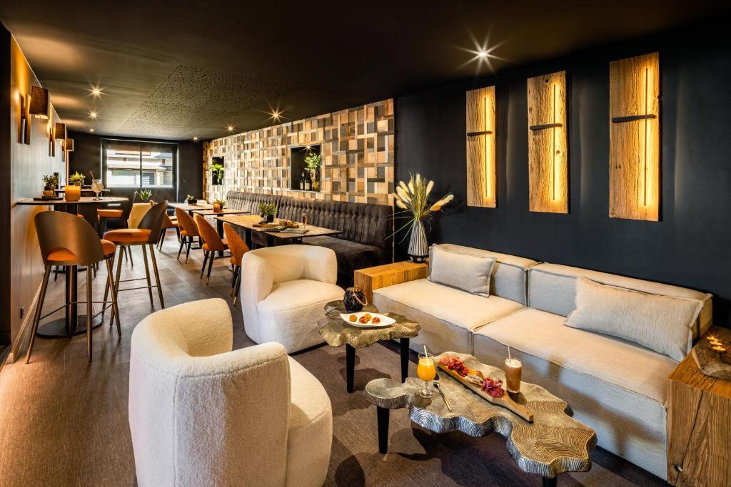 克莱尔沃雷拉克Logis Hôtel LBB - les 2 lacs的带沙发和桌子的客厅以及酒吧。