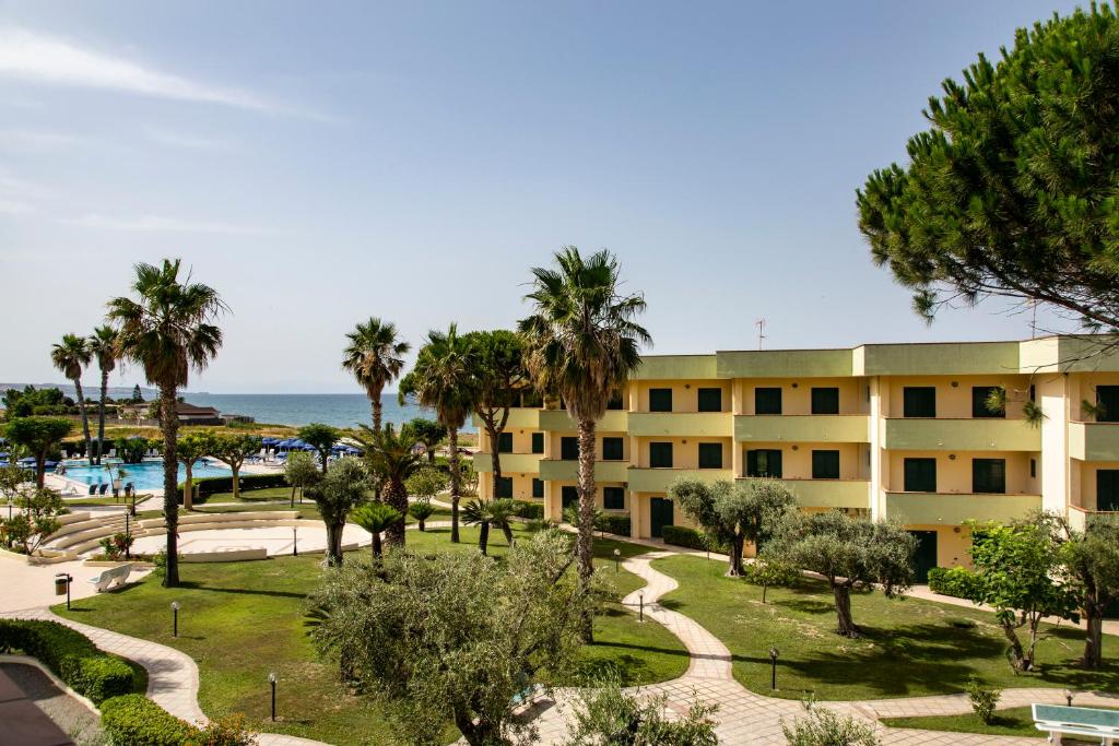 曼达托里乔码头天堂村酒店的享有棕榈树和大海的建筑景致