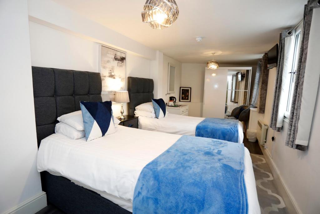 贝克斯利Bexley Village Hotel的蓝色和白色的酒店客房内的两张床