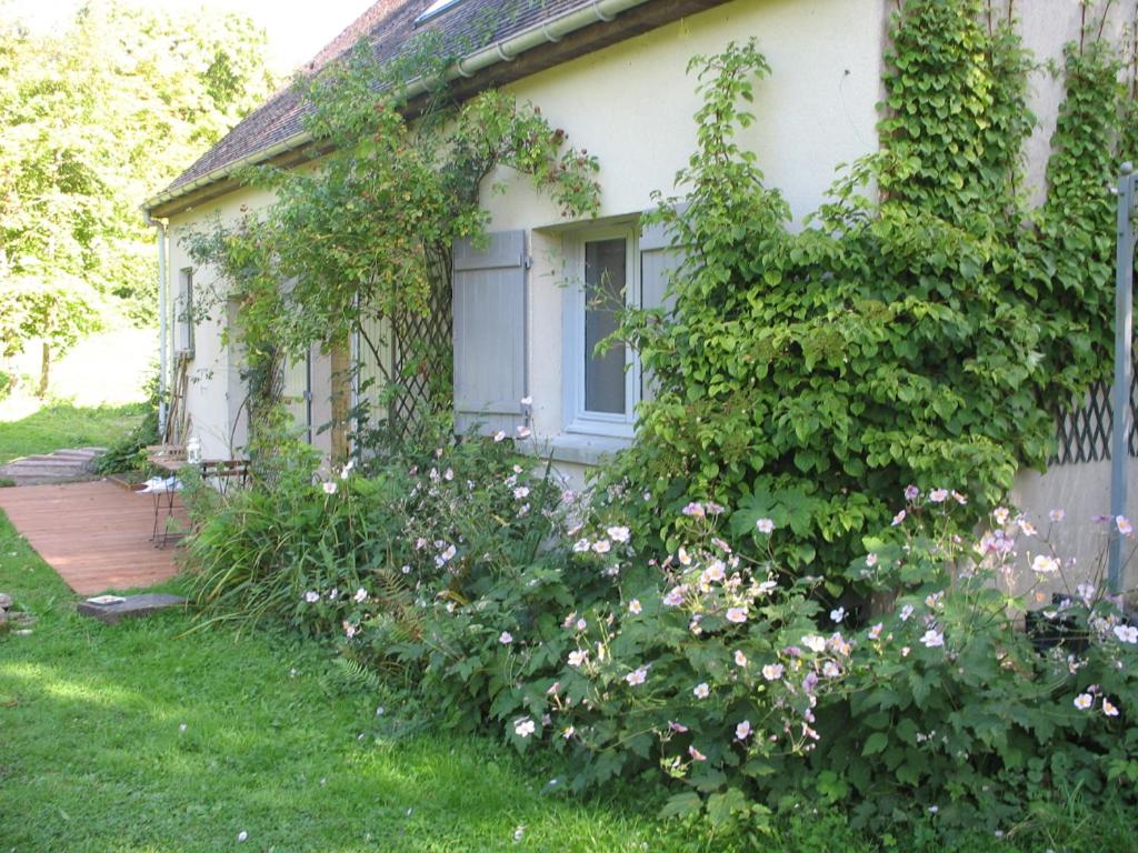 Avilly-Saint-Léonard勒布拉姆住宿加早餐旅馆的白色的房子,有窗户和一些鲜花