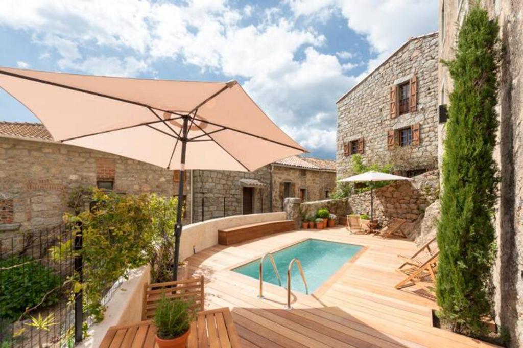 FozzanoMaison Madamicella的一个带遮阳伞和游泳池的庭院