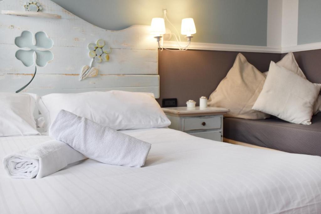 泰塞拉Venicegreen Agriresort的卧室配有白色的床铺和白色的枕头