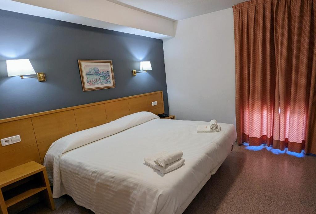 圣胡安·德·阿利坎特桑塔法兹酒店的一间卧室配有一张床,上面有两条毛巾