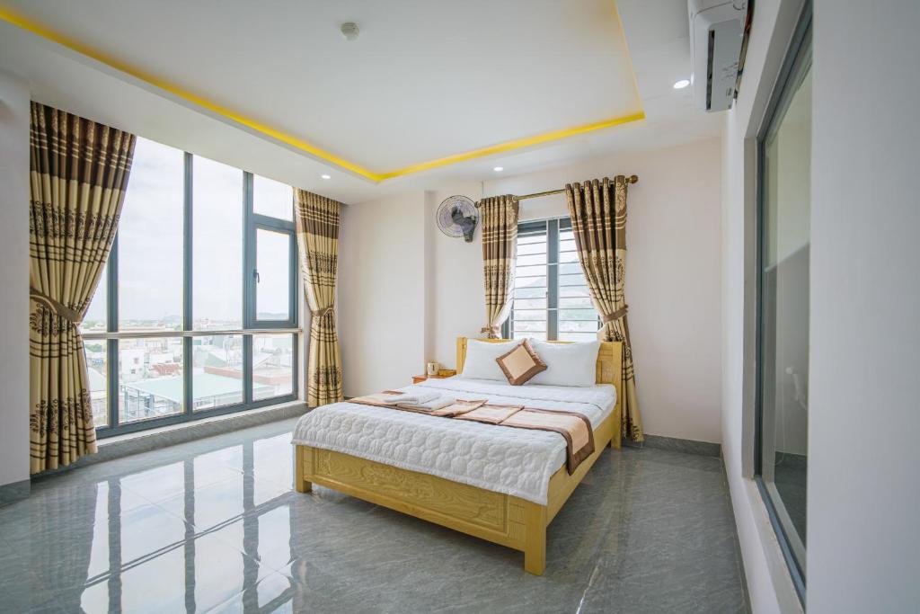 归仁Phú Xuân Hotel的一间卧室设有一张床和大窗户