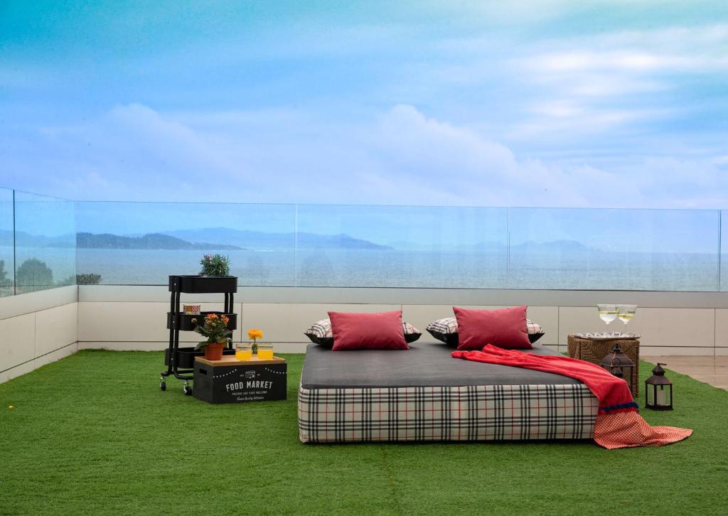 桑亨霍Luxury Singular Villa Canelas的一间铺有绿色地毯并配有红色枕头的床的客房