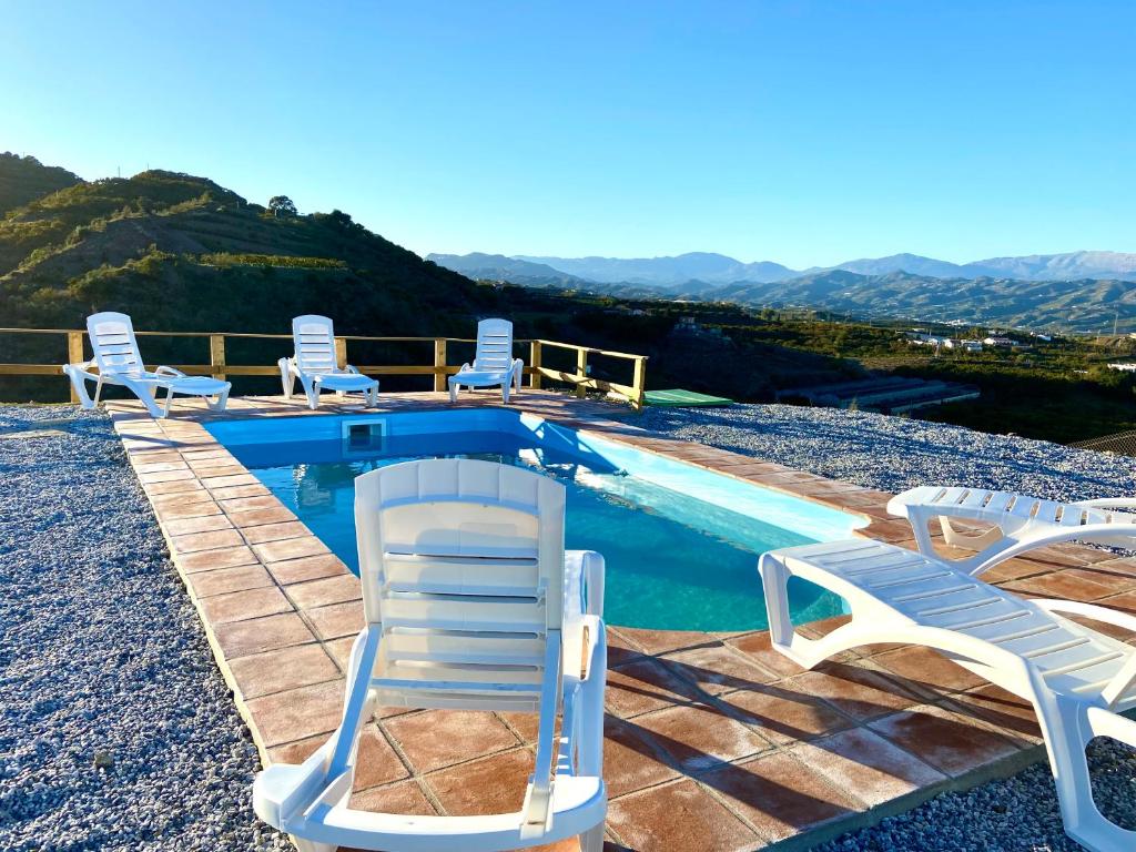 贝莱斯Casa El Barranco By Solymar Holiday的一个带草坪椅的游泳池和一个游泳池