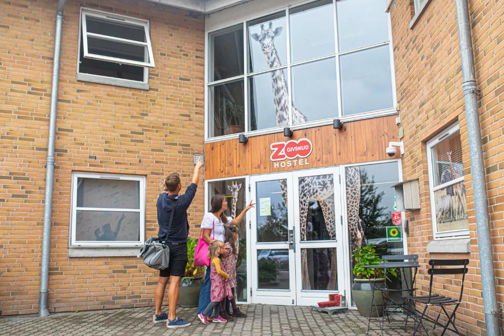GivskudGivskud Zoo Hostel的两名妇女站在砖房外面