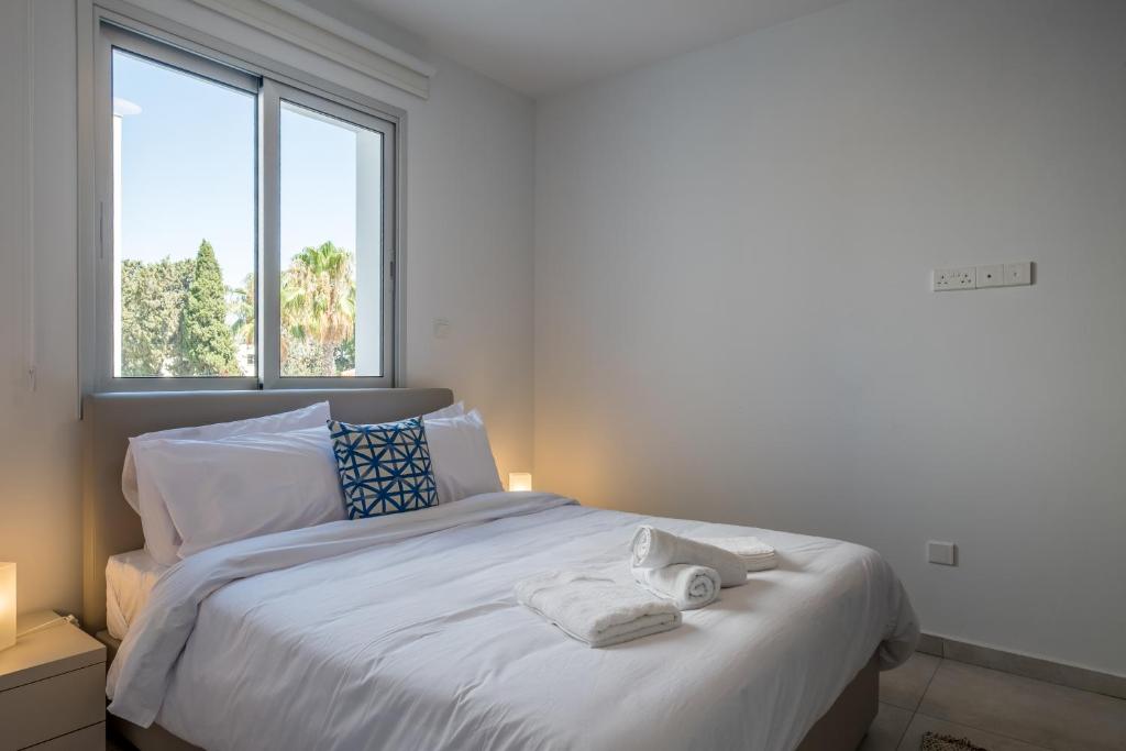 拉纳卡Solaar Apartments Faneromeni的卧室配有白色的床和2条毛巾