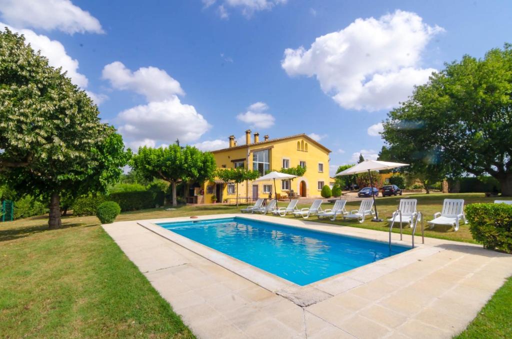 SilsClub Villamar - Can Metlla的一个带椅子的庭院和房子的游泳池