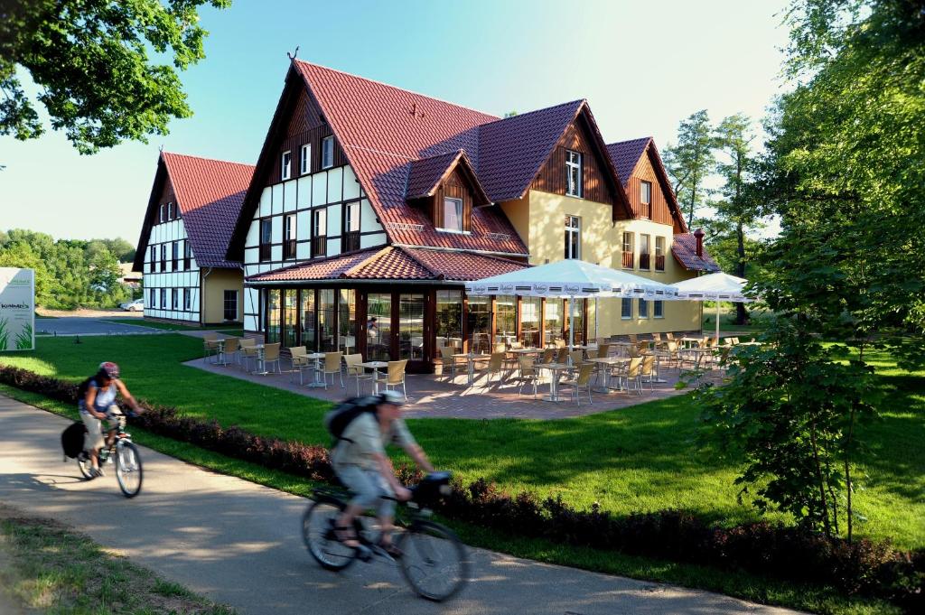 布尔格Kur und Wellnesshaus Spreebalance, The Originals Relais (Relais du Silence)的两人骑车在大楼前