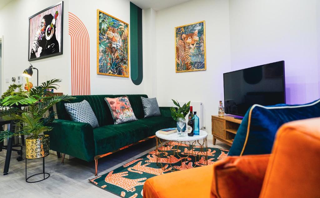斯蒂夫尼奇Spacious Luxury Apartment in Stevenage, Sleeps 6, with Free Parking, and Free Wi-Fi的客厅配有绿色沙发和电视