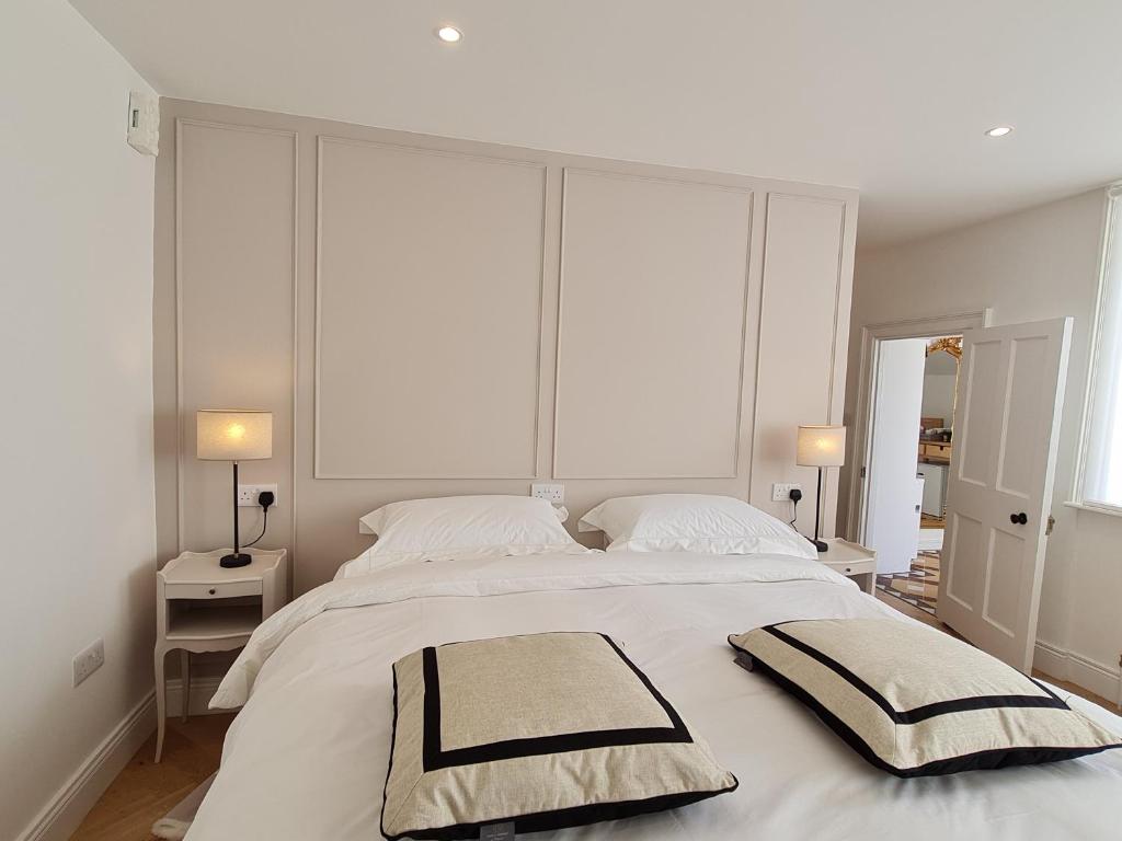 都柏林彭布罗克套房公寓的卧室配有一张带两个枕头的大白色床