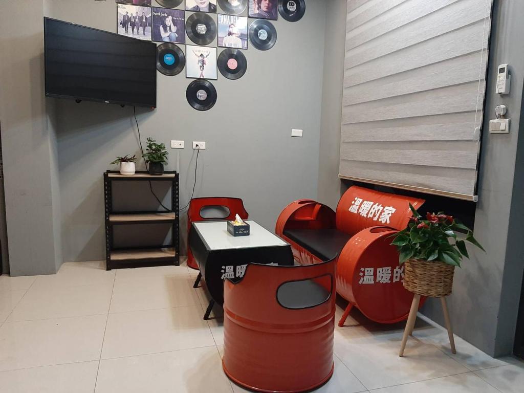 Hsia-san-chieh秧月民宿的一间设有红色椅子、电视和桌子的房间