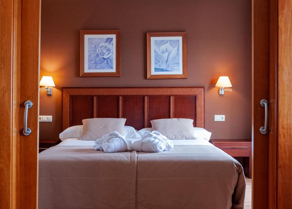 莱昂ARVA Santiago León的卧室配有一张墙上有两张照片的床。