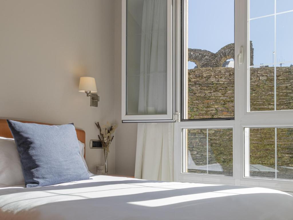 卢戈Hostal ALBA Lugo的一间卧室设有一张床和一个美景窗户。