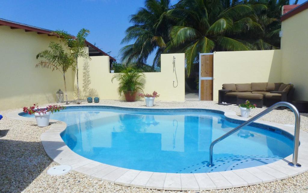 棕榈滩布巴里花园公寓的庭院里的一个大型游泳池,配有沙发