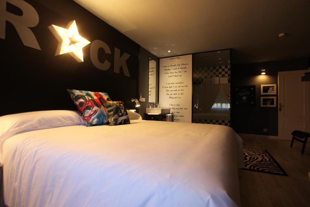 TaboadelaHotel Apartamentos Rock Star的卧室配有一张白色大床,墙上有一星星