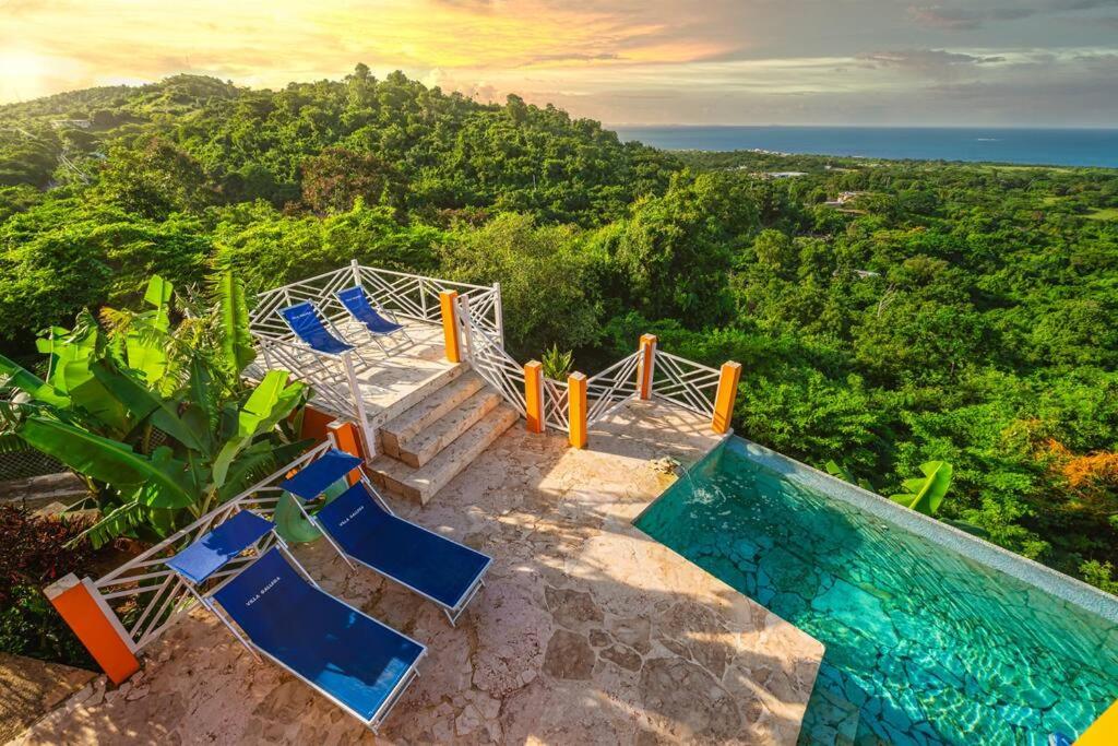 别克斯Vieques Villa Gallega - Oceanview w/Infinity Pool的一组蓝色椅子,位于游泳池旁