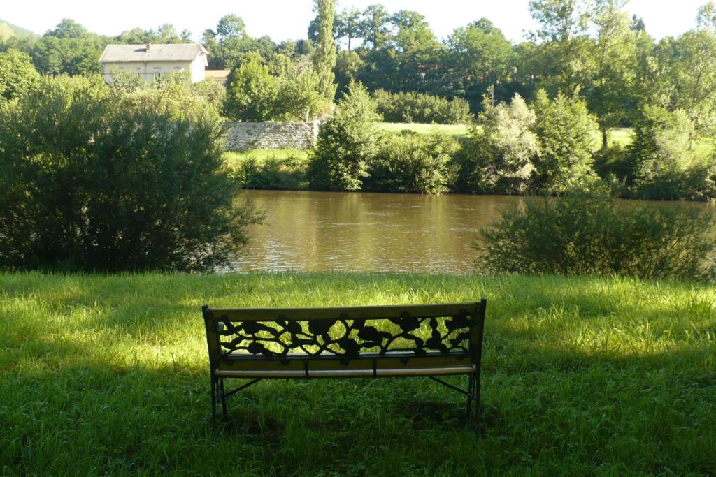 Lavoûte-sur-Loire拉武特美食住宿加早餐旅馆的坐在河边草地上的公园长凳