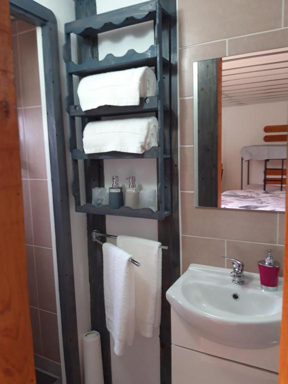 英雄港Alojamento Raminho dos Açores的浴室配有盥洗盆、镜子和毛巾