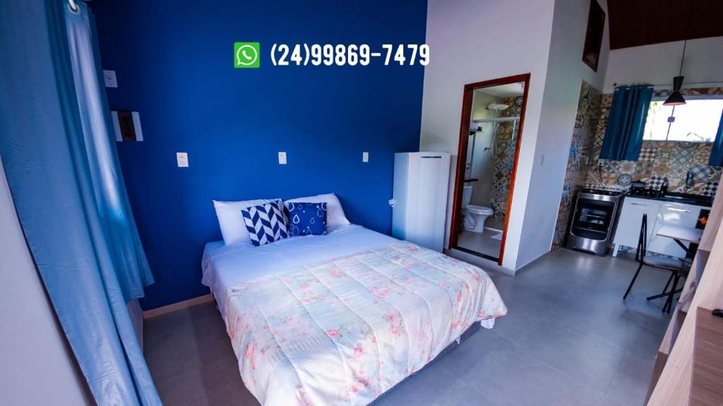 佩尼多Flats 2 Locação Penedo RJ的一间卧室设有蓝色的墙壁和一张床