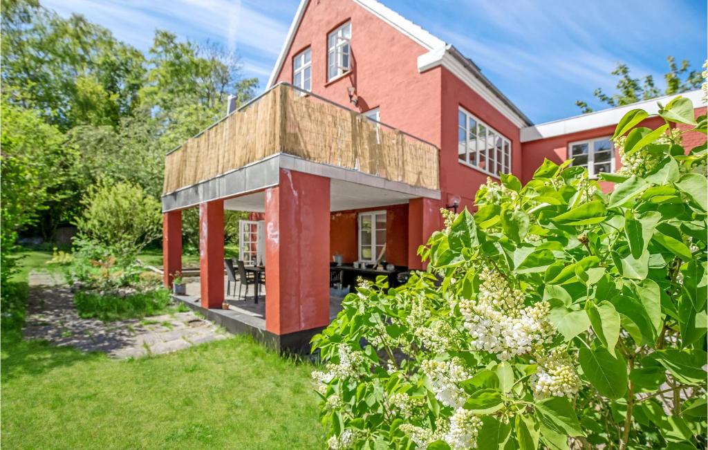 古兹耶姆Cozy Apartment In Gudhjem With Kitchen的前面有花园的红色房子