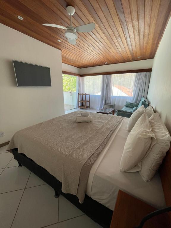 阿拉亚尔-杜卡布Orlanova Hotel的一间卧室设有一张带木制天花板的大床