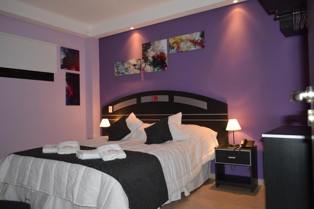 圣米格尔·德·图库玛Mercer Hostal的一间卧室设有一张紫色墙壁的大床