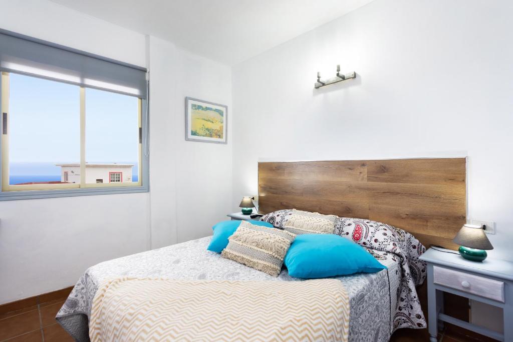 格拉纳迪利亚德亚沃纳EDEN RENTALS Atogo Cozy Apartment的一间卧室配有一张带木制床头板的床