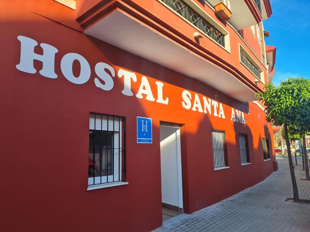 韦尔瓦Hostal Santa Ana的上面有社会圣徒标志的红色建筑