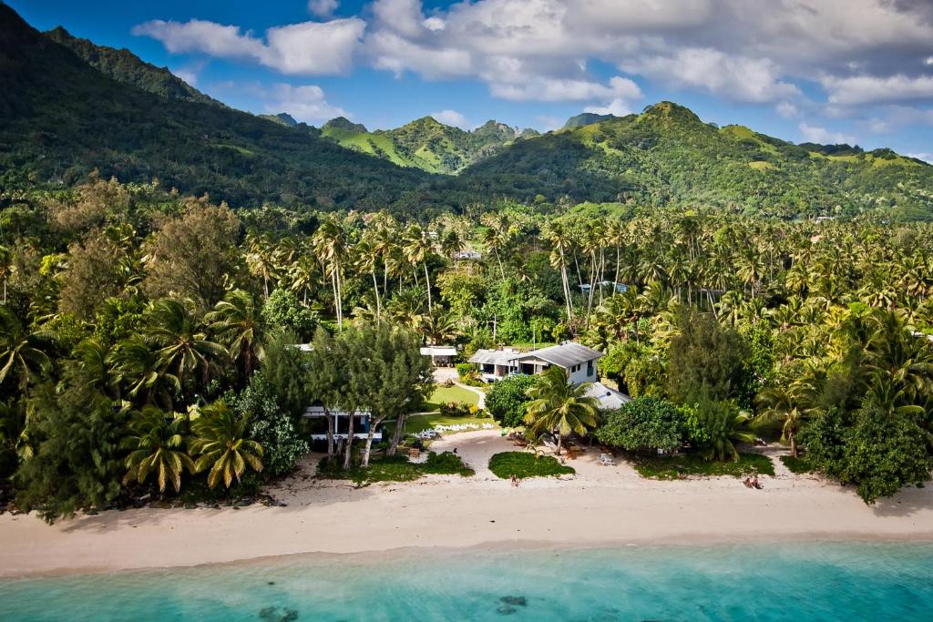 拉罗汤加Aroa Beachside Resort的棕榈树海滩上的度假村的空中景观
