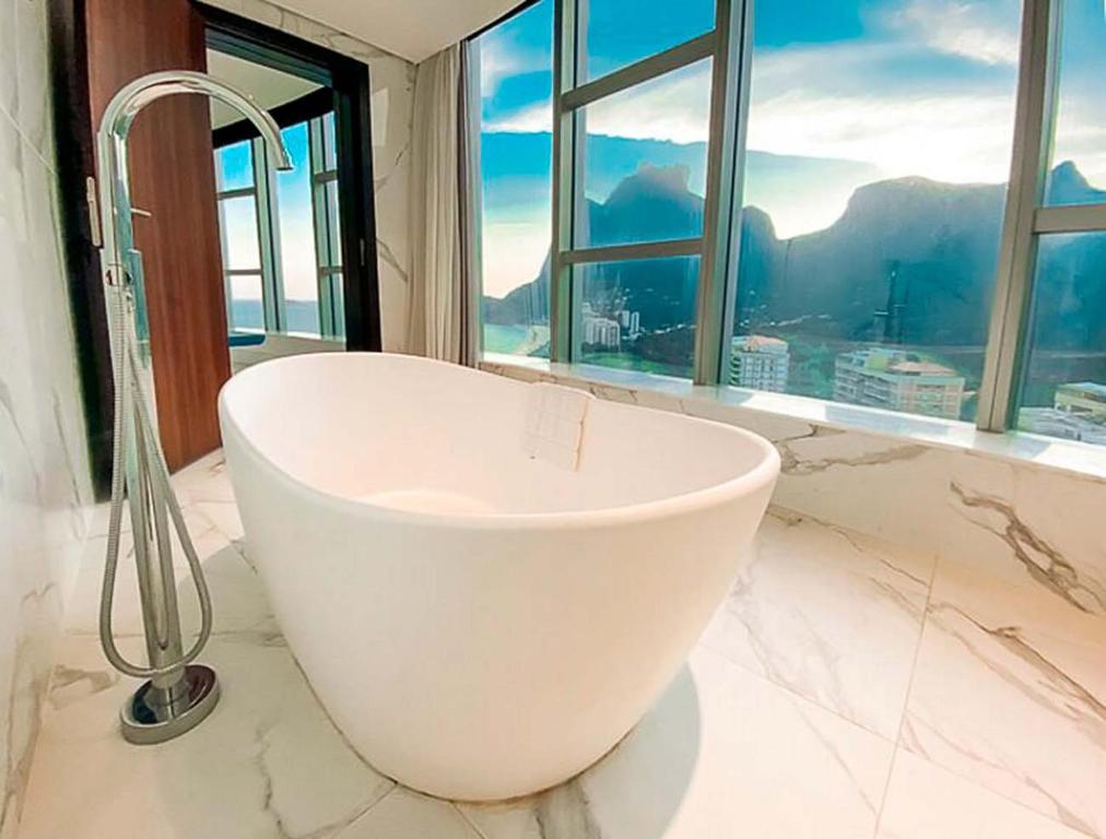 里约热内卢Hotel Nacional Vista Mar c/ Banheira的带窗户的浴室内的白色浴缸