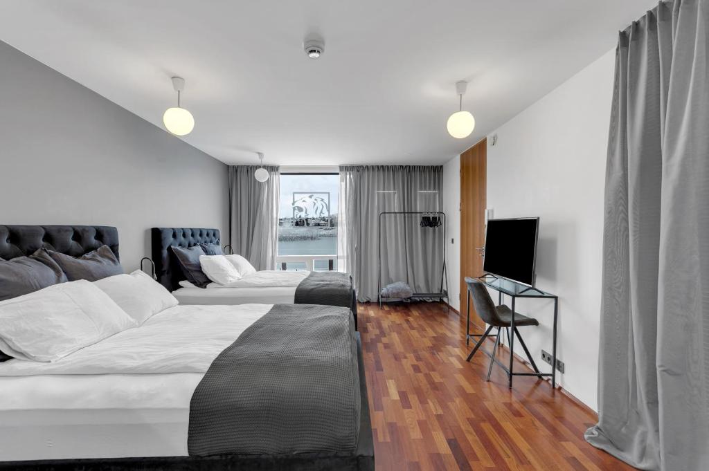 雷克雅未克Studio Apartment with Ocean View的酒店客房设有两张床和电视。