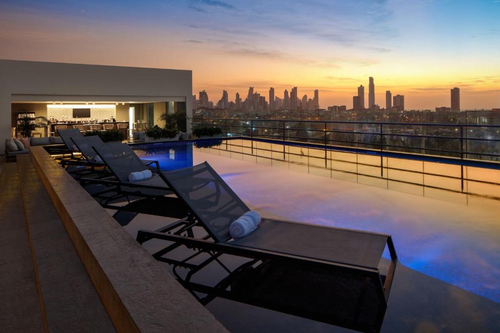 巴拿马城Marriott Panama Hotel - Albrook的建筑物屋顶上的一排躺椅