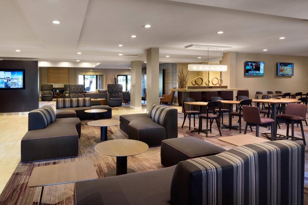 米尔皮塔斯米尔皮塔斯硅谷万怡酒店的酒店大堂设有沙发和桌子,还有一间酒吧