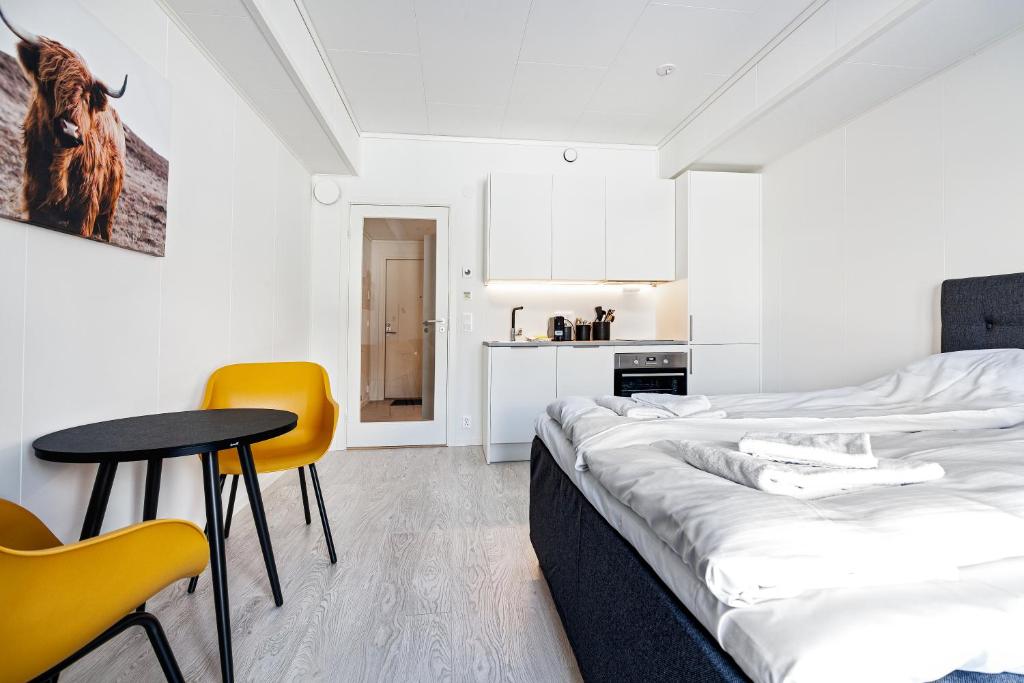 斯沃尔韦尔Stylish and serviced Studio apartment in Lofoten的一间设有两张床和一张桌子及椅子的房间