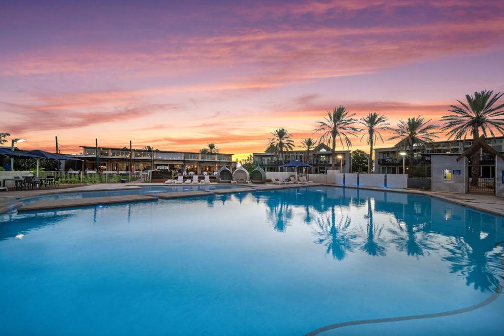 埃克斯茅斯曼塔雷宁格罗海滩度假酒店的一座享有日落美景的大型游泳池