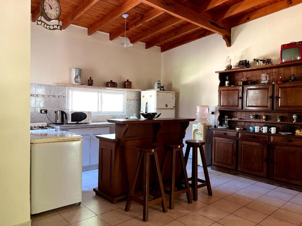 拉班达Finca Lo de Jose的厨房配有木制橱柜和带凳子的台面