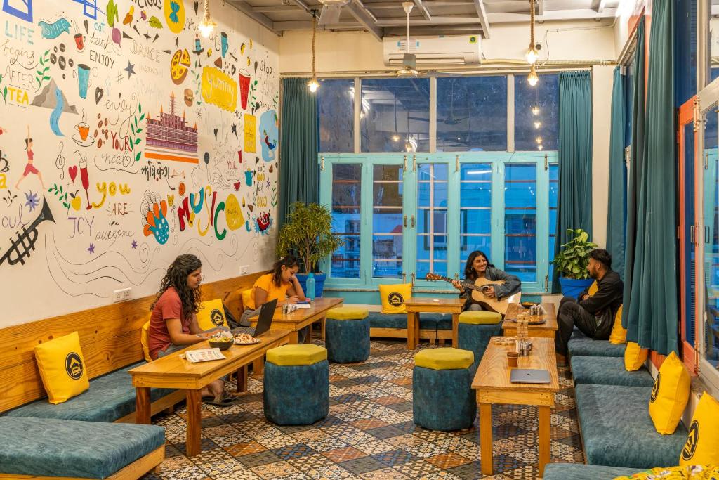 瑞诗凯诗The Hosteller Rishikesh, Upper Tapovan的一群坐在餐厅桌子上的人