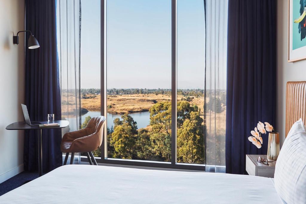 EppingMantra Melbourne Epping的酒店客房设有一张床和一个大窗户