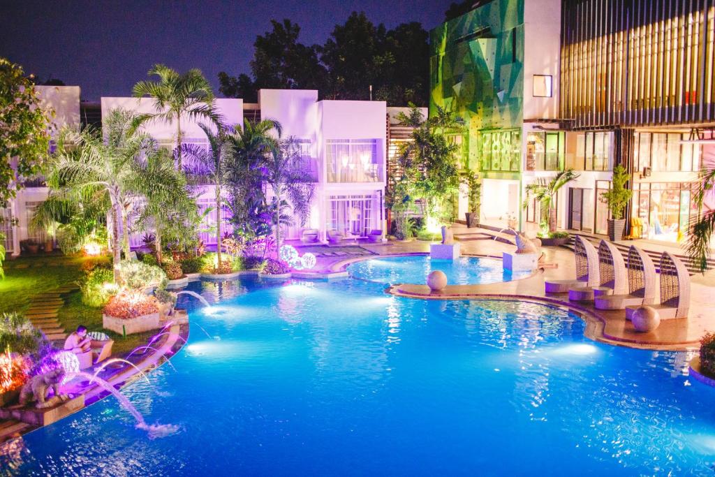 公主港阿齐扎天堂酒店 的夜间蓝色海水的度假村游泳池