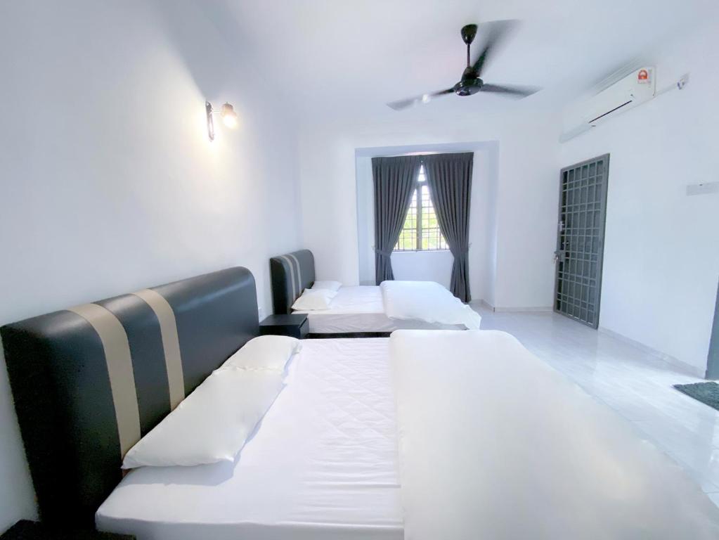 卢穆特Venice Guest Hostel - Bilik Sahaja的带三张床和窗户的客房