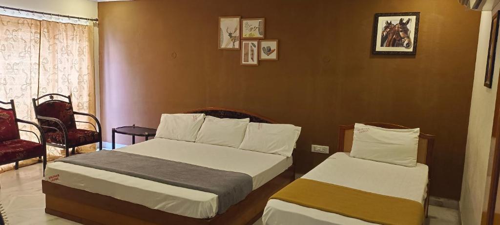斯里卡拉哈斯蒂Sridhar Lodge的酒店客房设有两张床和窗户。