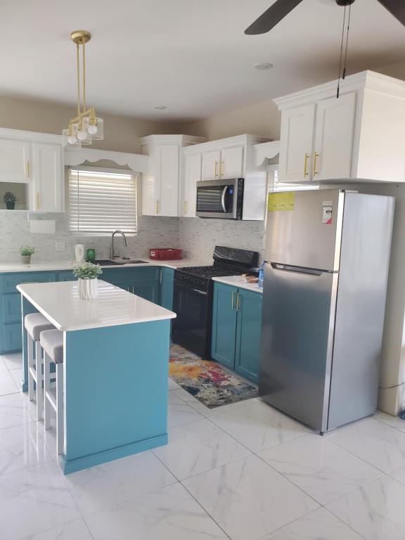 Level27 Pent的厨房配有蓝色橱柜和不锈钢冰箱
