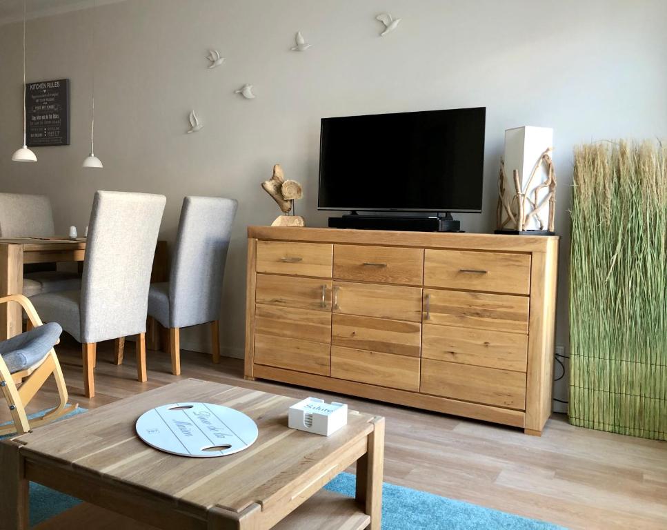 海利根达姆Lindenpalais Wohnung 24的客厅配有木梳妆台上的电视