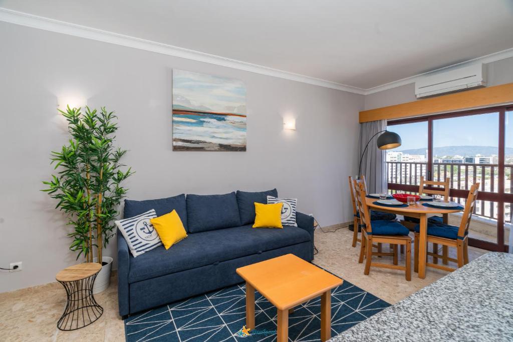 波尔蒂芒Praia Mar - Apartamento Viva Local的客厅配有蓝色的沙发和桌子