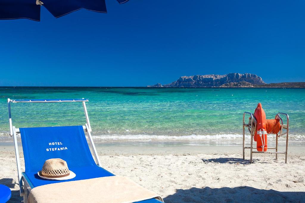 奥尔比亚斯特法尼亚海滩边酒店的沙滩上的草帽和沙滩椅